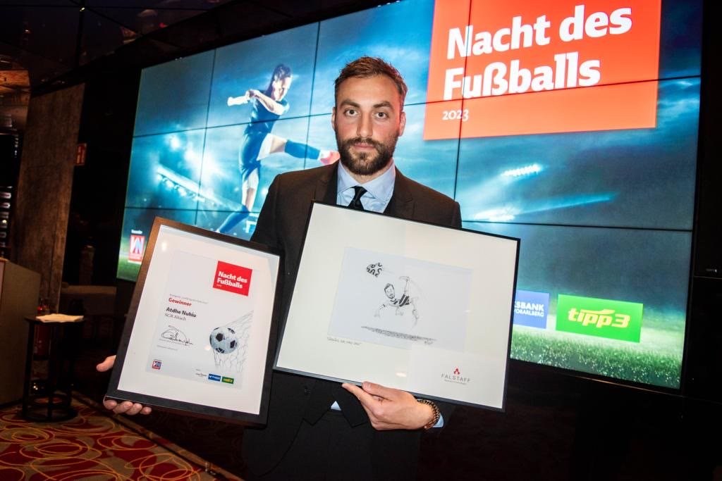 Atdhe Nuhiu mit Urkunde und Zeichnung bei der Nacht des Fußballs 2023